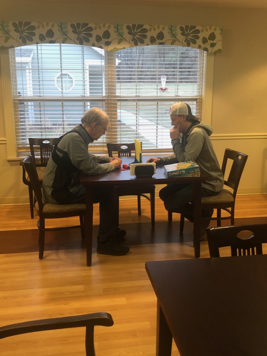 A volunteer plays a fun game with an Origami resident.