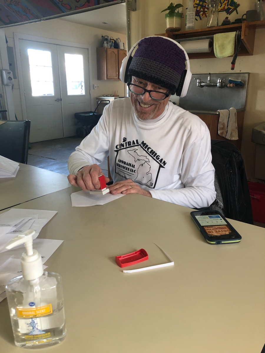 A volunteer helps stamp envelopes.