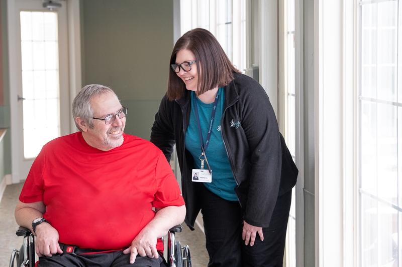 Direct Support Professional walks with a residential client.