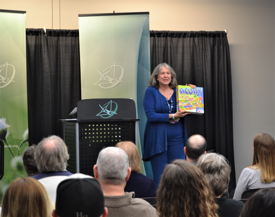 A 2019 Evening of Reflections storyteller holds up a visual to help share her story with the audience