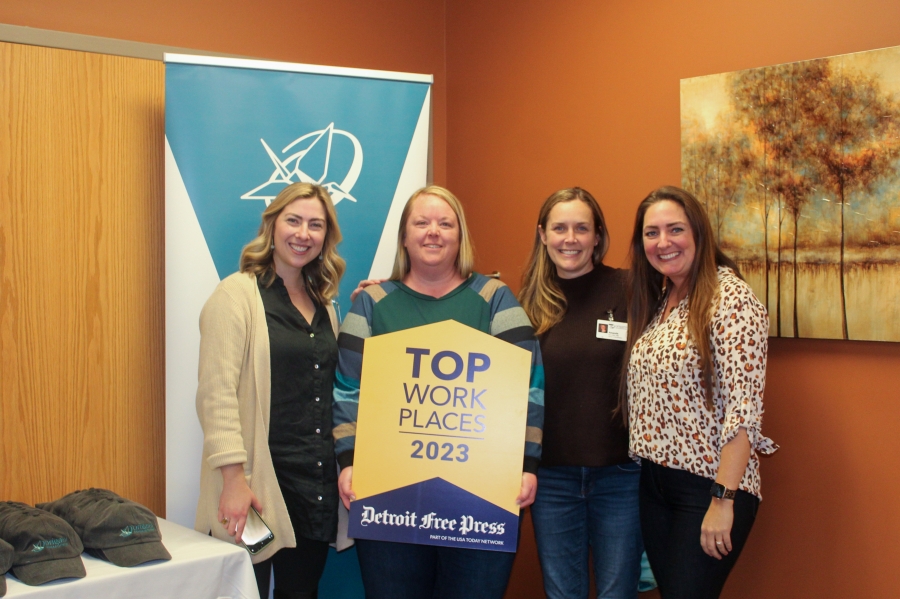 Origami Team members hold the top workplaces sign and smile (1)