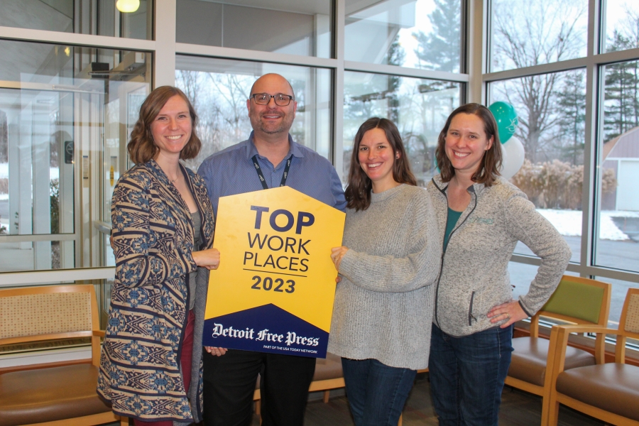 Origami Team members hold the top workplaces sign and smile (2)