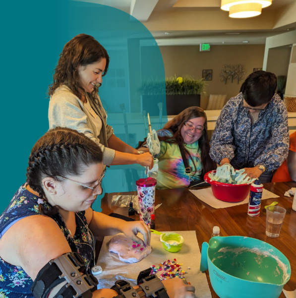 Origami Day treatment clients work with a team member on a recreational therapy activity