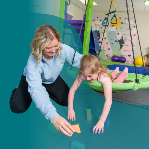 Origami Occupational Therapist works with pediatric client in the therapy gym