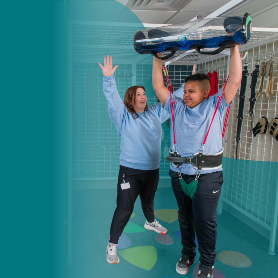 Origami physical therapist working with pediatric client in therapy gym
