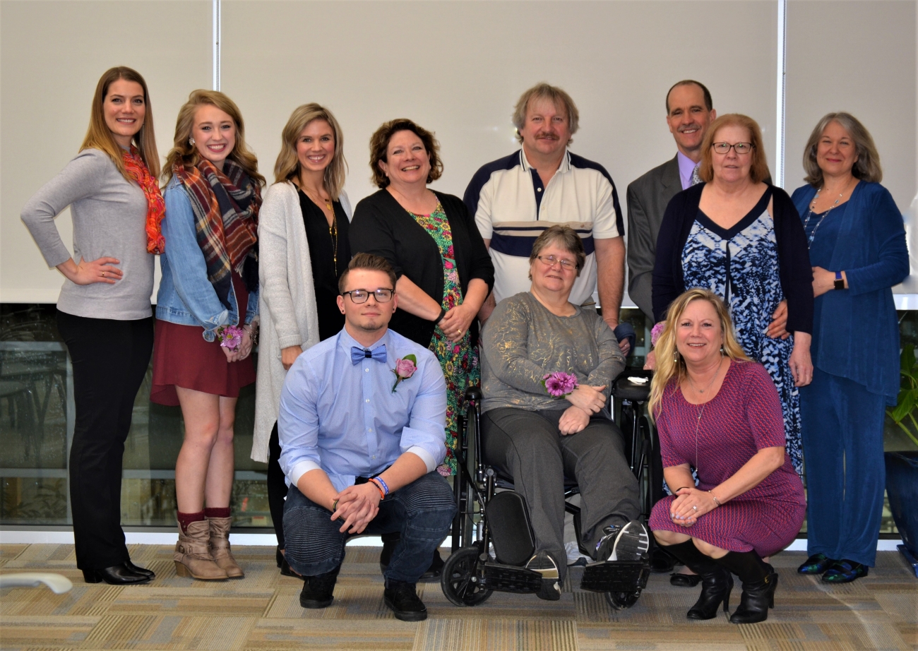 A group of clients grouped together smiling at the camera