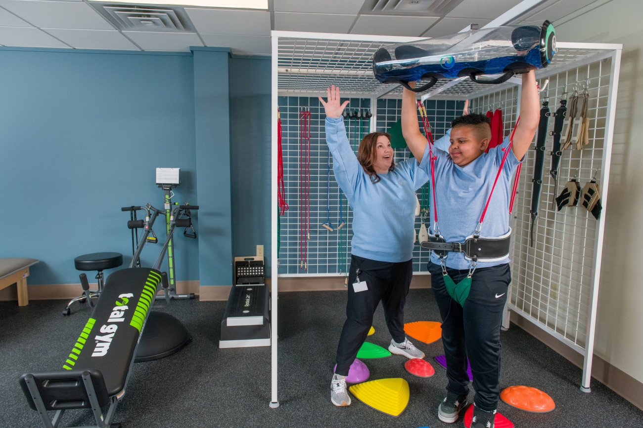Image of therapist and child doing physical therapy